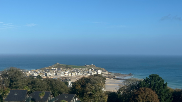 Scenic view of St Ives, Cornwall, showcasing the town and beach from a picturesque hilltop perspective.