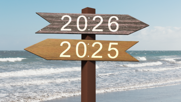 Two wooden signs directing towards 2025 and the 2026 representing the past and future.